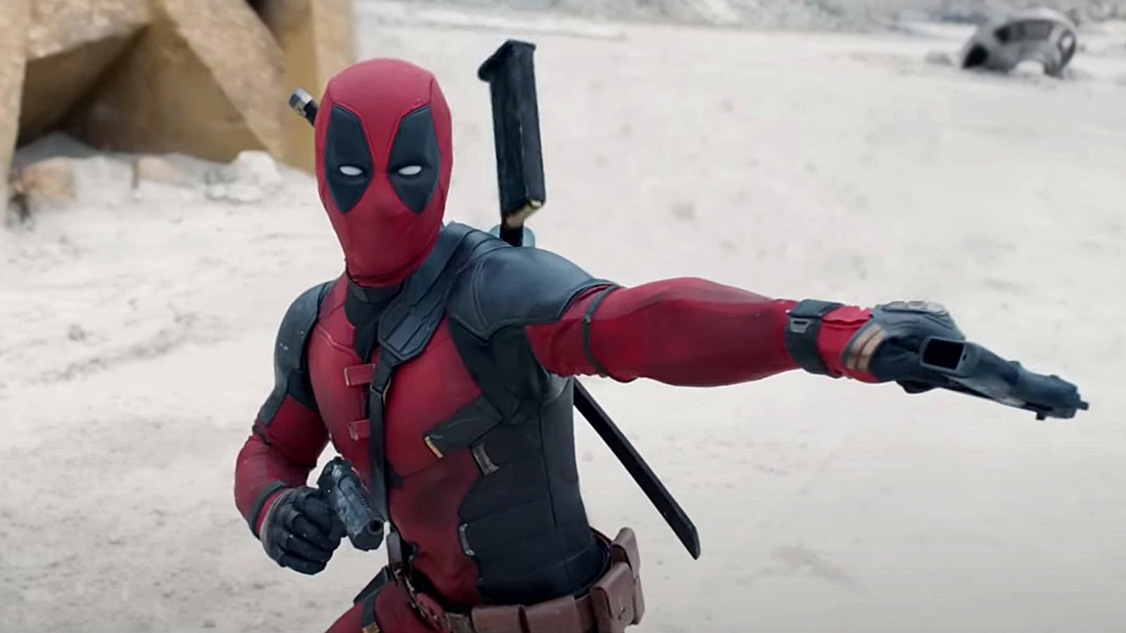 Ryan Reynolds Deadpool rolünde, elinde silah tutuyor